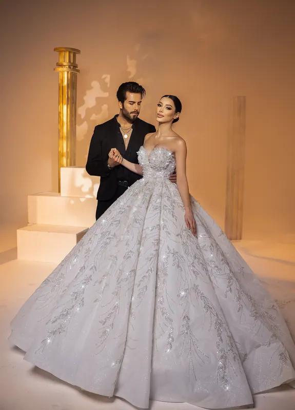 Couple between gold columns, full-length ball gown