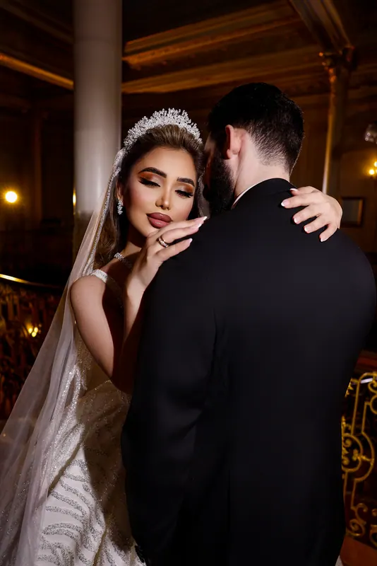 Bride and groom embracing in a gilded palace hall