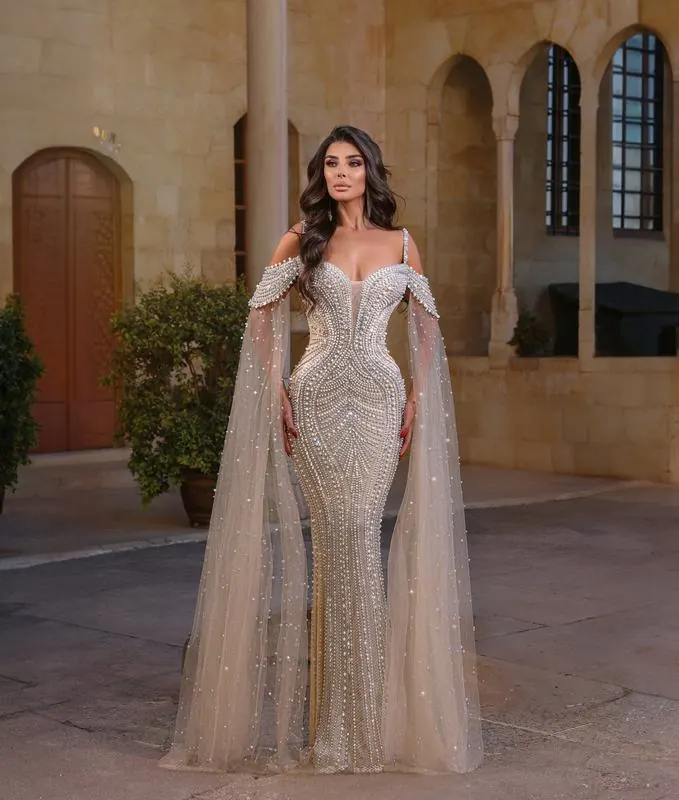 Beaded gown with cape in a stone courtyard