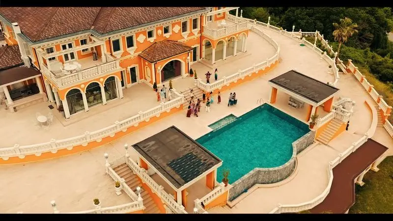 Drone shot of a seaside villa with a pool party