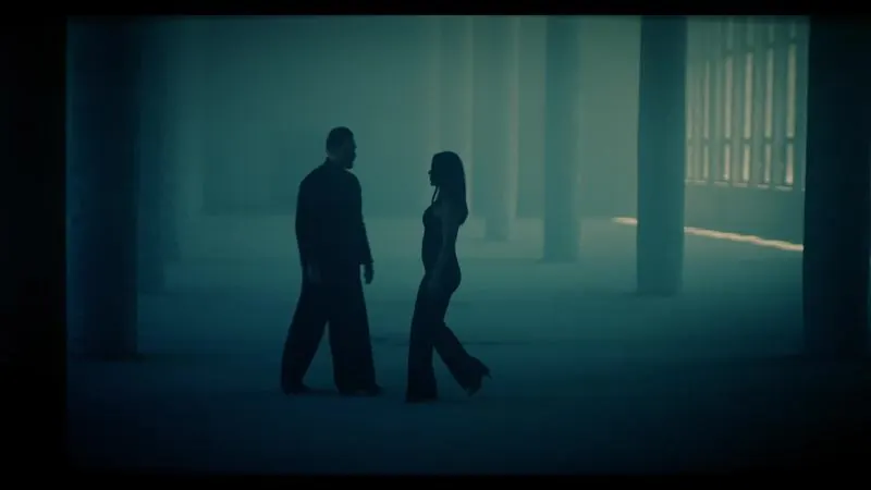 Two silhouettes in a misty industrial hall