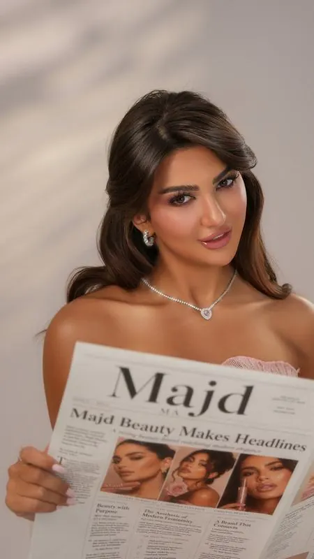 Model holding a Majd Beauty newspaper