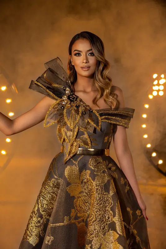 Gold brocade gown with a sculpted shoulder
