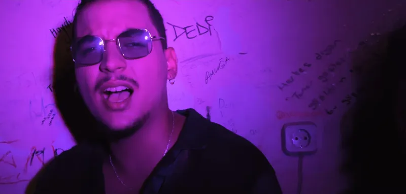 Singing to camera under purple light