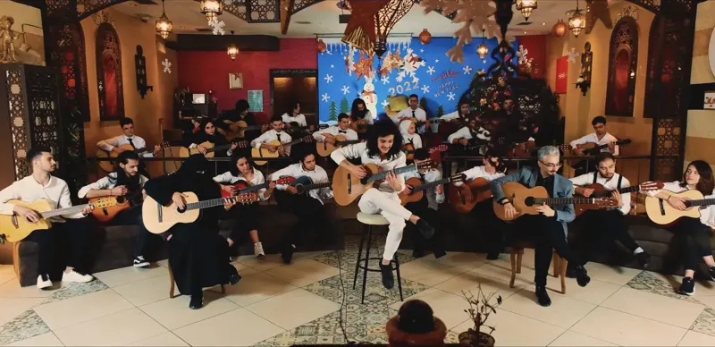 The guitar orchestra playing together in a decorated hall