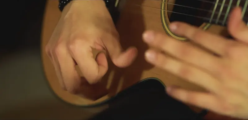 Close-up of hands on a guitar