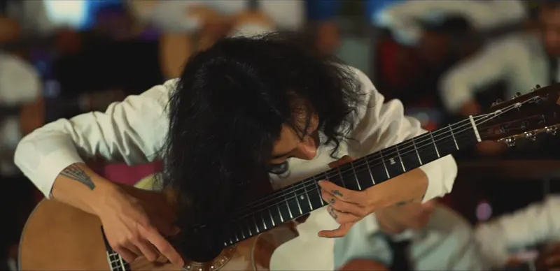 The soloist bent over his guitar